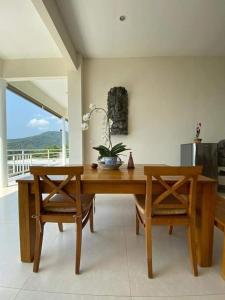 a dining room with a wooden table and two chairs at Villa Aryaguna in Senggigi 