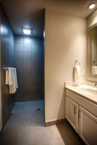 a bathroom with a shower and a sink and a mirror at Z Loft Extended Stay Hotel in Saint Robert