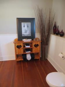 a bathroom with a table with a tv on it at That Country Place B&B in Hanna