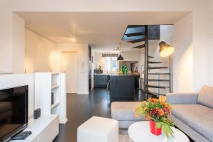 a living room with a couch and a table with flowers at Flagey Penthouse Duplex in Brussels
