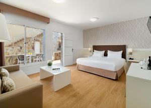 een slaapkamer met een bed en een woonkamer bij Hotel Arena Suite in Corralejo