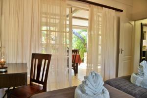 a living room with a table and a glass door at Chobe River Cottages in Kasane