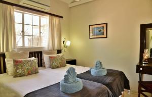 a hotel room with two beds and a window at Chobe River Cottages in Kasane +31 photos