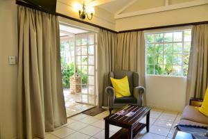 uma sala de estar com uma cadeira e uma janela em Chobe River Cottages em Kasane
