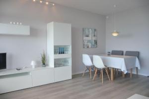 a white dining room with a table and chairs at Ferienresidenz-79-5 in Staberdorf