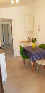a dining room with a table and green chairs at House Mergi in Pomer