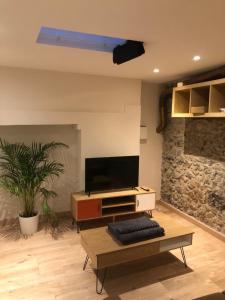 a living room with a tv and a table at Immeuble de charme La Tronche in La Tronche