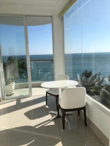 a white table and chairs in a room with a large window at Homestay coco in Vung Tau