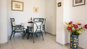 un comedor con sillas y una mesa con flores en Apartment Vistamar 2, en Chayofa