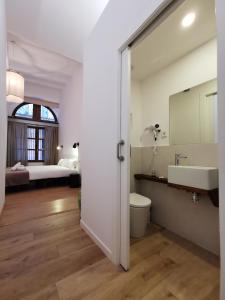 bagno con lavandino, servizi igienici e specchio di ClassBedroom Port Ramblas a Barcellona