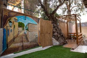 um mural na lateral de um edifício com uma árvore em Mendy's Accommodation em Safed