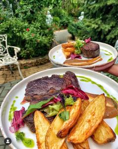 two plates of food with steak and potatoes on a table at Korall in Mykolaiv