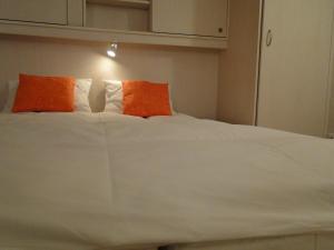un letto con due cuscini arancioni e bianchi di Alb Studio a St. Blasien