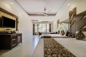 a hotel room with two beds and a flat screen tv at Hotel Royale Palace in Mount Ābu
