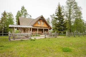 ein Holzhaus auf einem Feld mit einem Zaun in der Unterkunft Arma Riding Farm And Holiday Home in Rutja