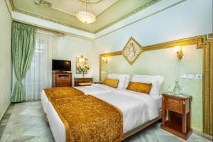 Postel nebo postele na pokoji v ubytování Imperial Palace Classical Hotel Thessaloniki