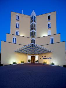 a large white building with a large entrance at Hotel Belmondo Leipzig Airport in Wiedemar