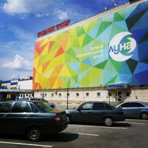 un gran edificio con coches estacionados en un estacionamiento en Luna Hotel, en Yekaterinburg