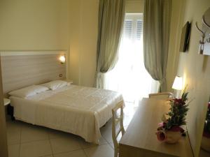 En eller flere senge i et værelse på Hotel Parrini