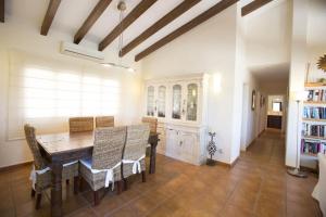 uma sala de jantar com uma mesa de madeira e cadeiras em Villa Pita - Deniasol em Denia