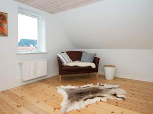 a living room with a chair and a fur rug at 4 person holiday home in Esbjerg V in Esbjerg