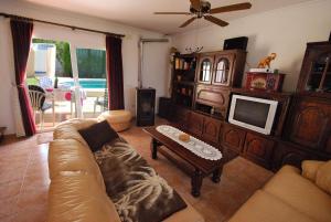 a living room with a couch and a tv at Villa Bugamvilla - Deniasol in Denia