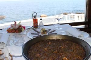 a pot of food sitting on a table with a view of the ocean at Apartamento Cascadas - Deniasol in Denia