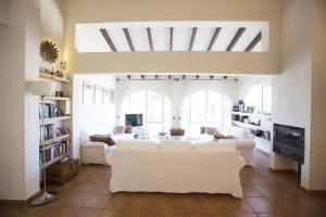 sala de estar con sofá blanco y TV en Villa Pita - Deniasol, en Denia