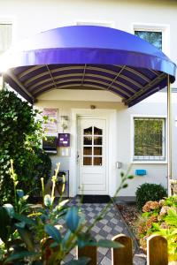 a purple cover over the front door of a house at Aparthotel Messe Flughafen in Düsseldorf