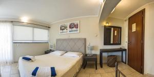 1 dormitorio con 2 camas, escritorio y ventana en San Nectarios en Parga