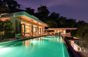 a swimming pool in front of a house at night at Villa Skyfall Thailand Phuket in Panwa Beach