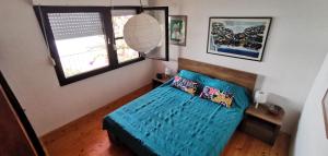 a bedroom with a blue bed and two windows at Holiday Home Prizba in Prizba