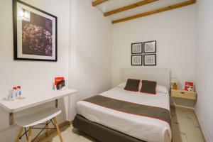 a small bedroom with a bed and a desk at Hostal Austria in Granada +31 photos