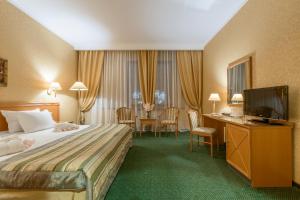 a hotel room with a bed and a flat screen tv at Suleiman Palace Hotel in Kazan
