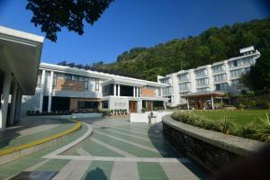 a large white building with a mountain in the background at Allita Hotel & Resorts in Kurseong