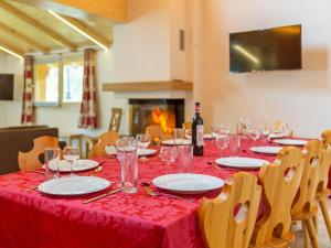 ラ・ズマにあるA new chalet with sauna on the edge of La Tzoumazの赤いテーブルクロスとワイングラス付きのテーブル