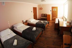 Habitación de hotel con 4 camas, mesa y sillas en Motel WiG, en Sandomierz