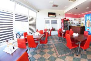 un comedor con sillas y mesas rojas en un restaurante en Motel WiG, en Sandomierz
