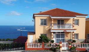 a house with a fence in front of the ocean at Apartamentos Casa Junonia in Alajeró