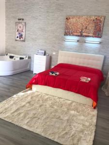 een slaapkamer met een bed met een rode deken en een bad bij Villa Suite Deluxe in Siracusa