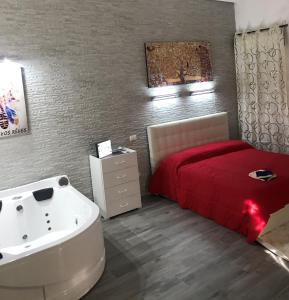 een slaapkamer met een bed en een bad naast een wastafel bij Villa Suite Deluxe in Siracusa
