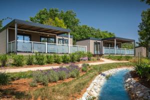 una casa con un río delante de ella en Premium Camping Homes Santa Marina, Lanterna, en Poreč
