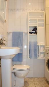 a bathroom with a sink and a toilet and towels at Marlenghi Apartments View Canteras in Las Palmas de Gran Canaria
