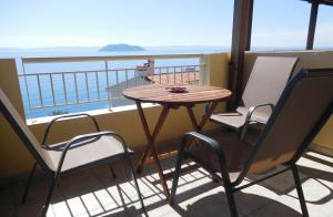 een tafel en stoelen op een balkon met uitzicht op de oceaan bij Studios Stefania in Neos Marmaras