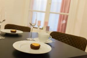 een tafel met een bord eten en wijnglazen bij Villa Gutenberg Residenz in Klagenfurt