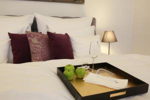 een dienblad met een wijnglas en peren op een bedje bij Villa Gutenberg Residenz in Klagenfurt