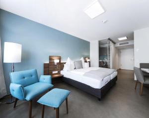 a bedroom with a bed and a chair and a desk at Apart-Hotel FirstBoarding Bayreuth in Bayreuth