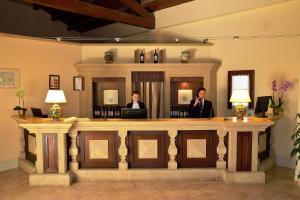 a man is standing in front of a desk at Hotel Baglio Oneto dei Principi di San Lorenzo - Luxury Wine Resort in Marsala