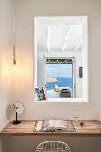 a bathroom with a mirror and a window at Mykonos Bliss - Cozy Suites, Adults Only Hotel in Kalo Livadi