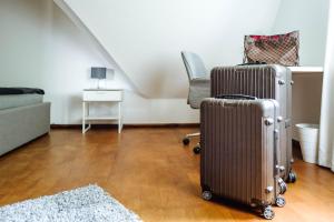 uma sala de estar com duas malas e uma cadeira em Doppelzimmer 150 m zur TA (Nr. 6) em Hameln